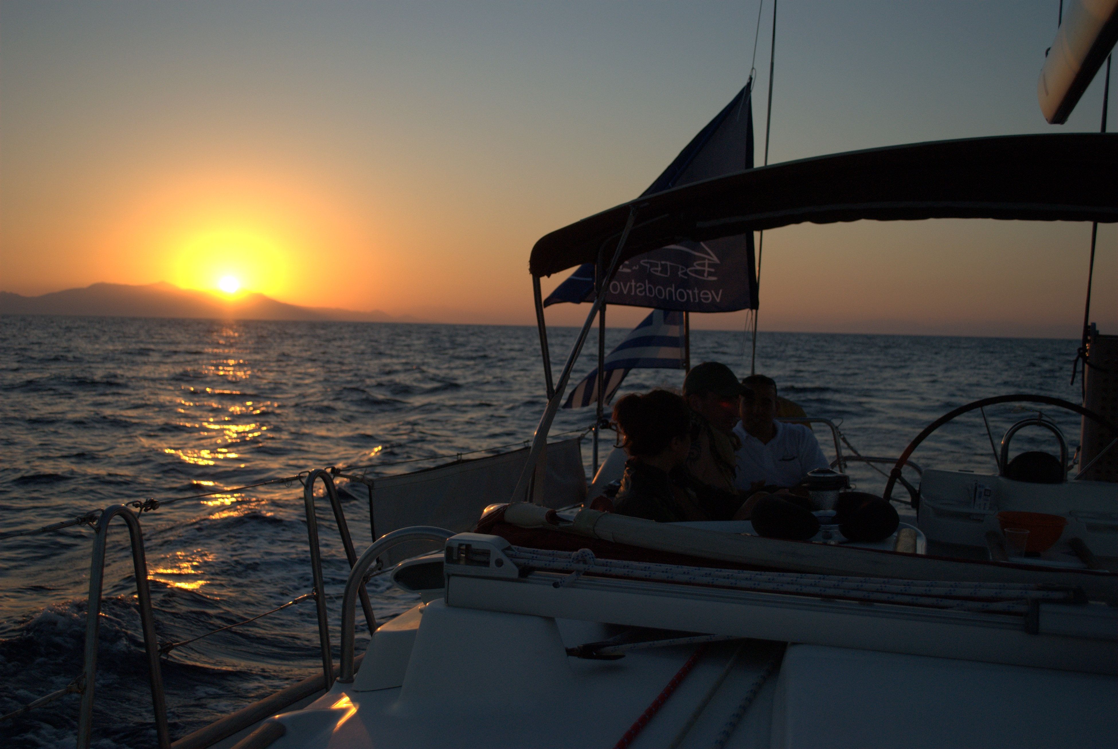 The Madeira 44 sailing at dusk, crew at the helm under the bimini.